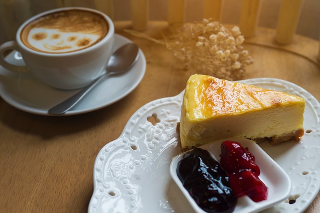 Free photo cheese cake with hot coffee cup on wooden table