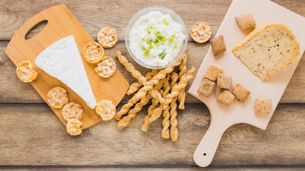 Free photo cheese cookies and bread sticks with cheese in bowl on wooden backdrop