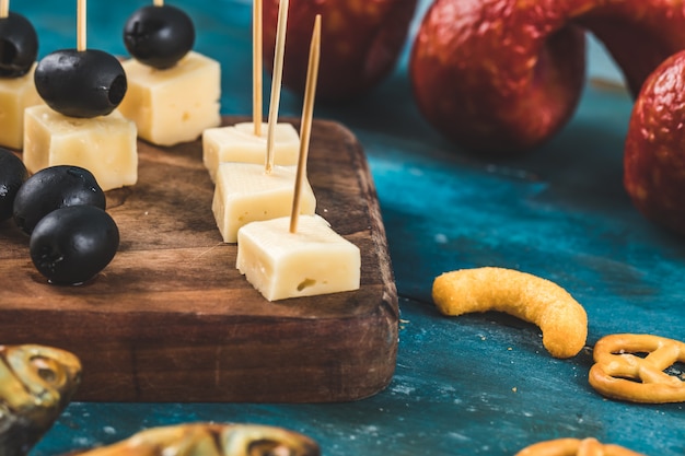 Free photo cheese cubes with black olives and other snacks