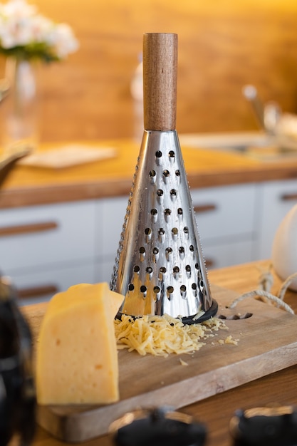 Free photo cheese is on the table near the iron grater, picture of a dinner rable