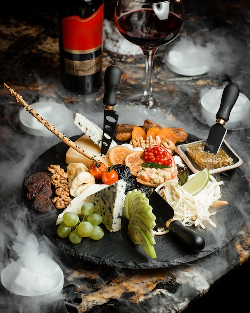 Cheese plate with parmesan blue and white cheese fruits and nuts