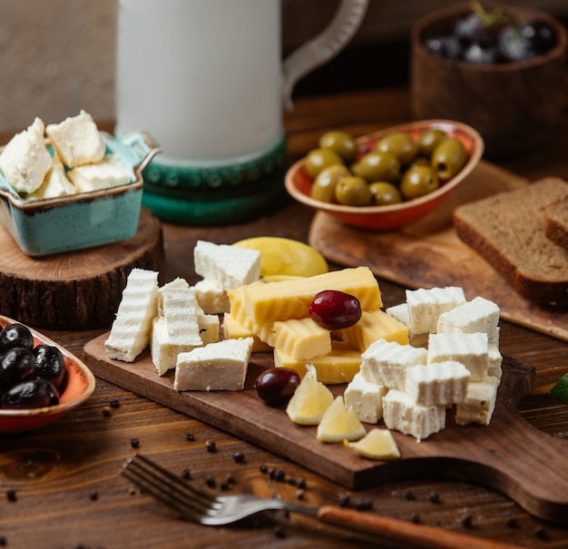 Cheese plate with white and gouda cheese, grape and lemon