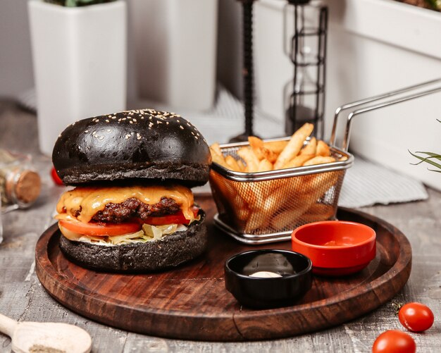 Free photo cheeseburger with black bun and fries