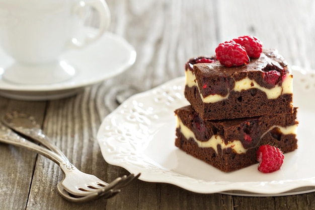 Cheesecake brownies with raspberry stacked on a plate