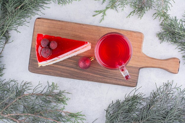 Cheesecake and glass of tea on wooden board with festive decorations. High quality photo