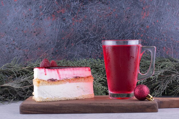 Cheesecake and glass of tea on wooden board with festive decorations. High quality photo