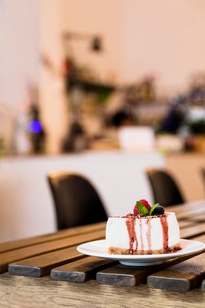 Cheesecake with berries and mint on wooden table in the coffee shop