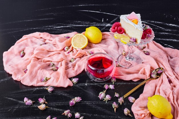 Cheesecake with fruits and tea on pink cloth. 