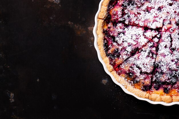 Cheesecake with raspberry on a dark wooden table