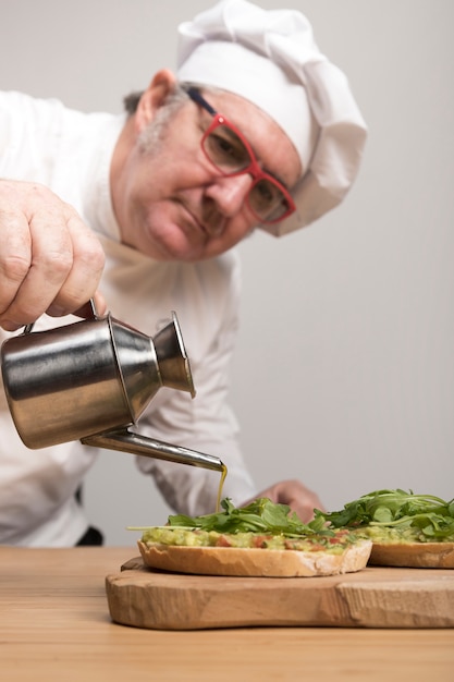 Chef adding oil on guacamole