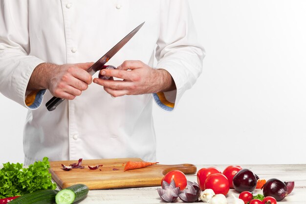 Chef cooking fresh vegetable salad in his kitchen