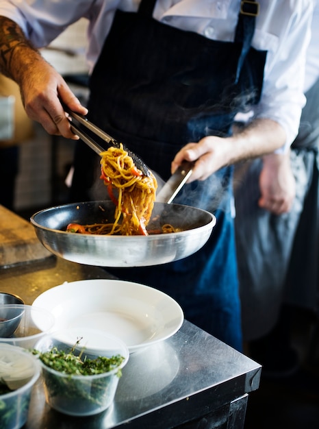 Chef cooking spaghetti in the kitchen