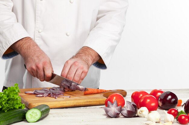 Chef cutting a onion on his kitchen