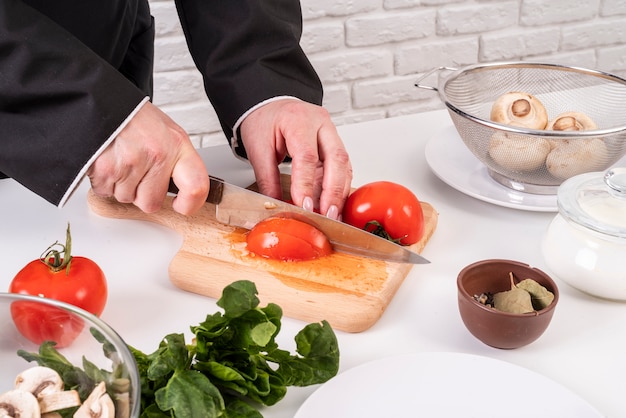 Chef cutting tomatoes