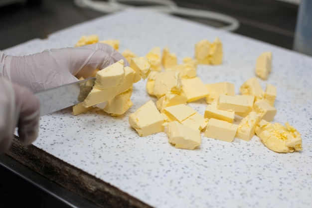 Chef cutting unsalted butter into pieces.