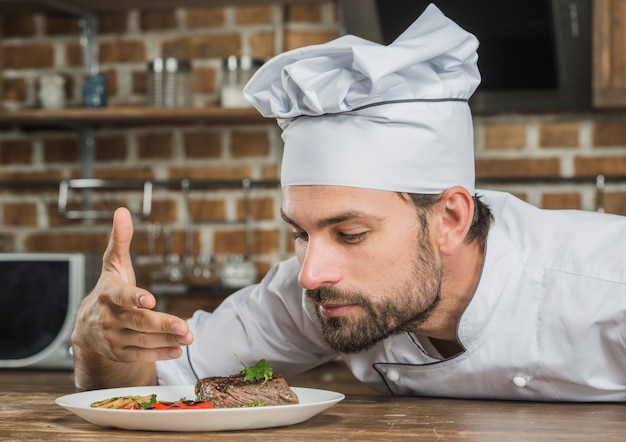 Free photo chef enjoying the aroma of served food on plate