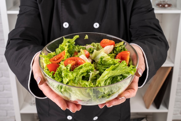 Free photo chef holding bowl of salad