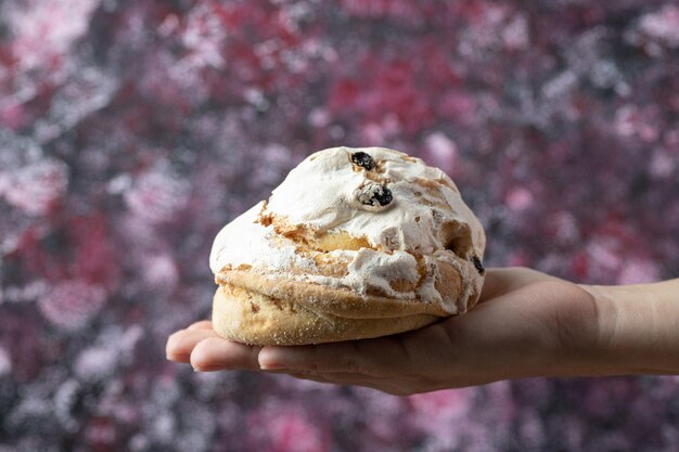 Chef holding crispy cookies with sugar powder in the hand.