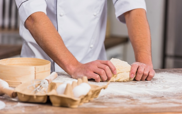 Chef in kitchen making dough