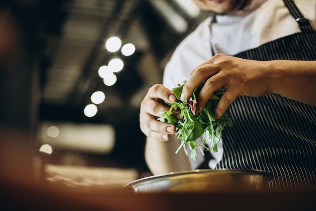 Free photo chef at the kitchen preparing salad