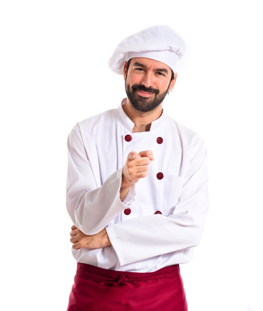 Chef pointing to the front over white background