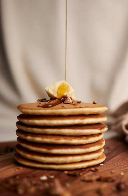 Free photo chef pouring maple syrup on a pile of delicious pancakes