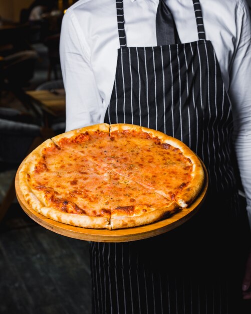 Chef presents margherita pizza on wooden board