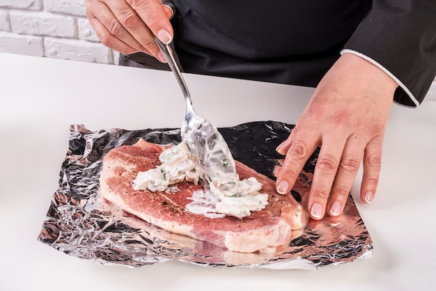 Free photo chef putting sauce of top of meat