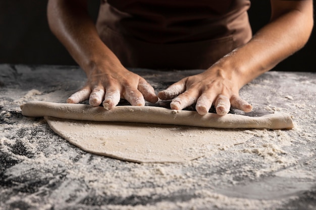 Chef rolling dough with a lot of flour on the table