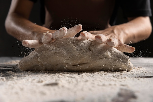 Free photo chef's hands kneading dough with flour