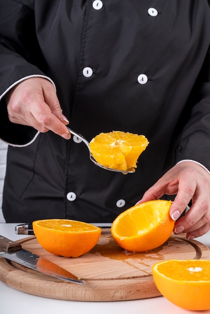 Free photo chef scooping oranges