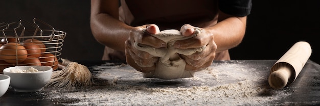 Free photo chef using hands to knead the dough