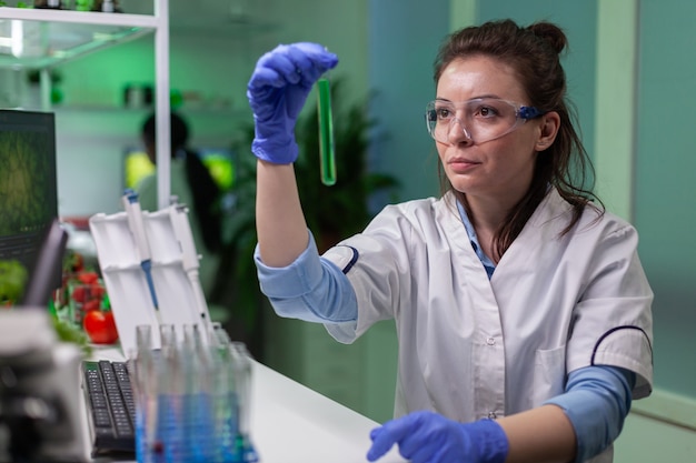 Free photo chemist looking at test tube with geneticaly modified liquid