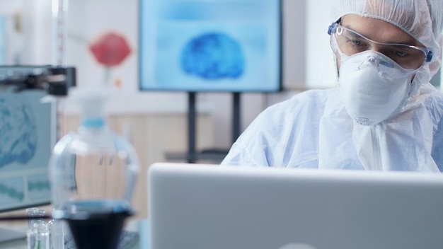 Free Photo chemist researcher doctor analyzing brain activity typing medical expertise on laptop computer during microbiology experiment. scientist man with ppe equipment working in biochemistry laboratory