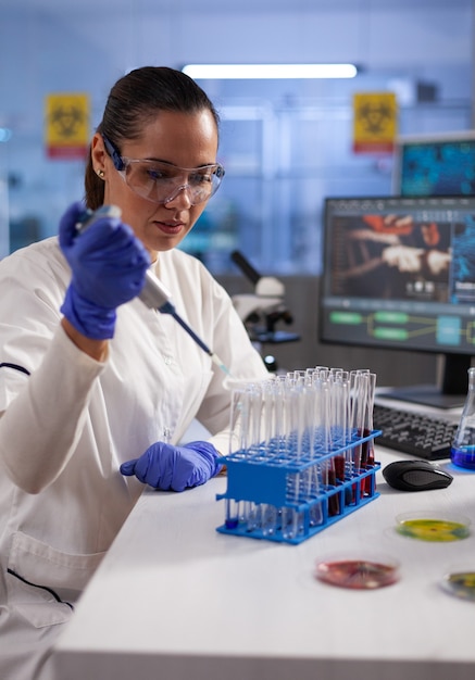 Chemist researcher dropping liquid in medical glassware using micropipette