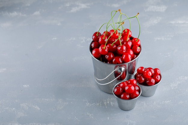 Free photo cherries in buckets. high angle view.