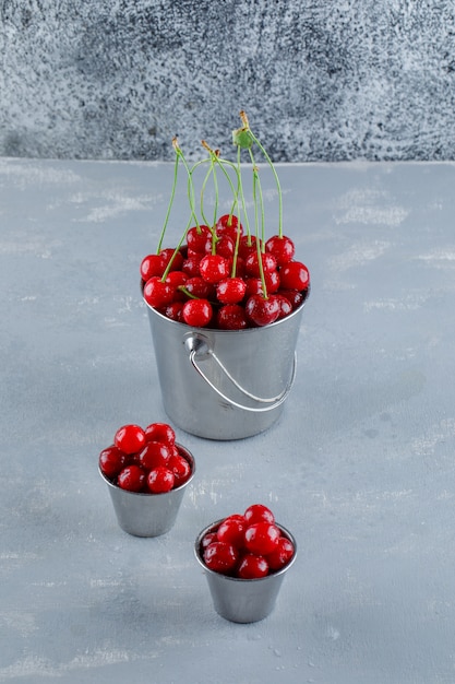 Free photo cherries in buckets, high angle view.