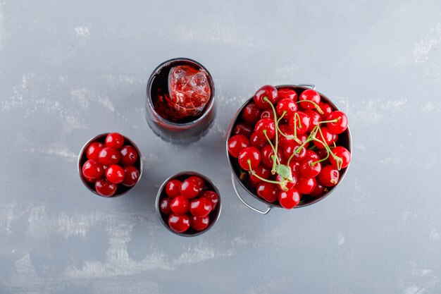 Cherries in buckets with juice top view