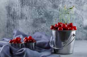 Free photo cherries in buckets with textile side view