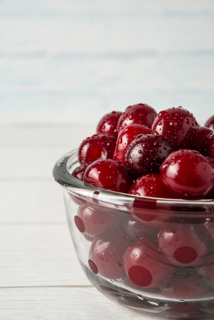 Free photo cherries in a glass bowl isolated on white