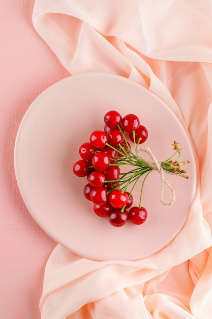 Free photo cherries in a plate flat lay