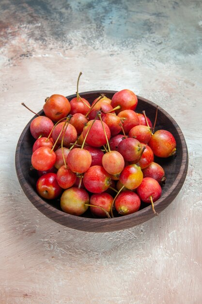 cherries red-yellow cherries in the wooden bowl on the table