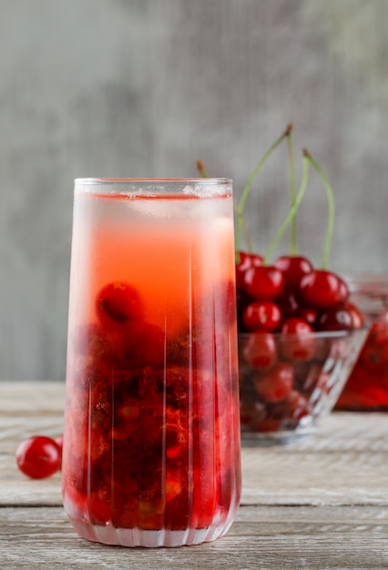 Free Photo cherry in a bowl with jam, cocktail side view on wooden