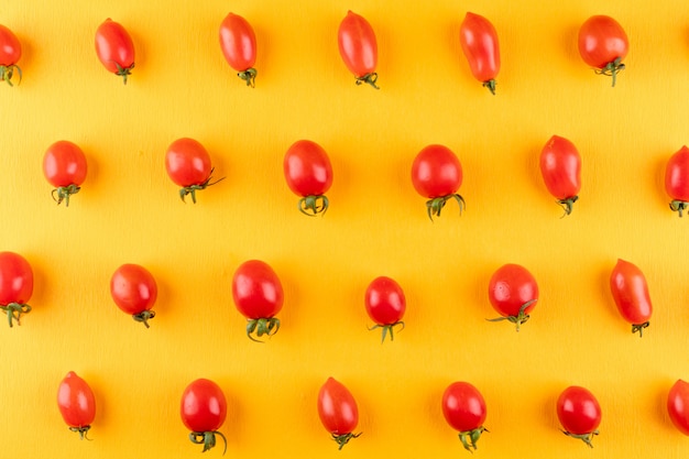 cherry tomatoes arranged row by row on yellow