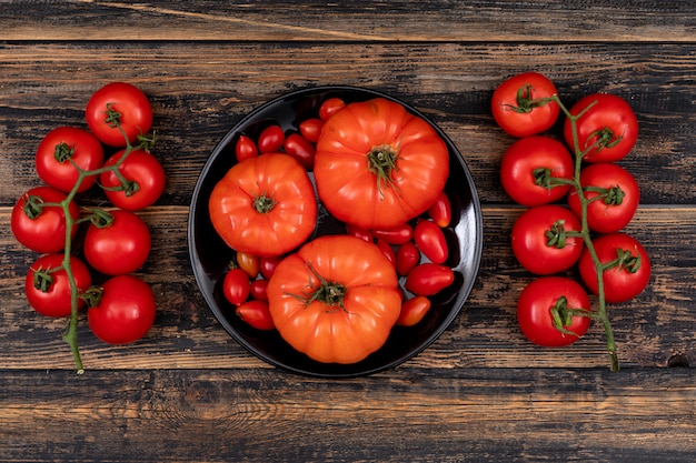 cherry tomatoes and big tomatoes in buddha bowl on a wooden table