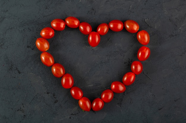 Cherry tomatoes heart shaped red cherry tomatoes on dark desk