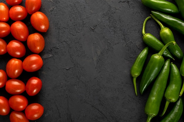 Cherry tomatoes red fresh and green spicy pepper on dark background