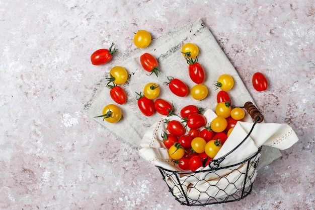 Cherry tomatoes of various colors,yellow and red cherry tomatoes in a basket on light background