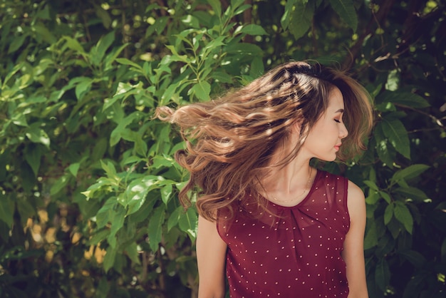 Free photo chest up shot of girl tossing her head with eyes closed in the sun