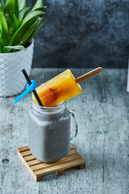 Chia milkshake with ice-cream and straw on the marble surface